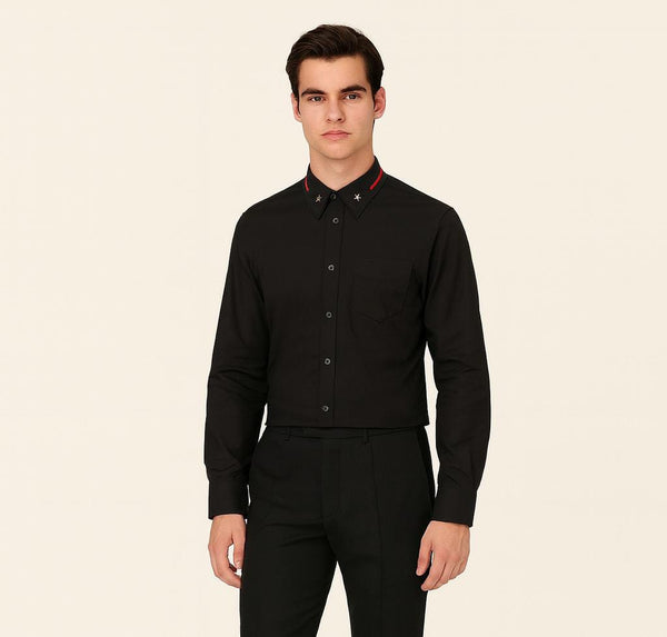 Man wearing a black dress shirt with red accents on a beige background